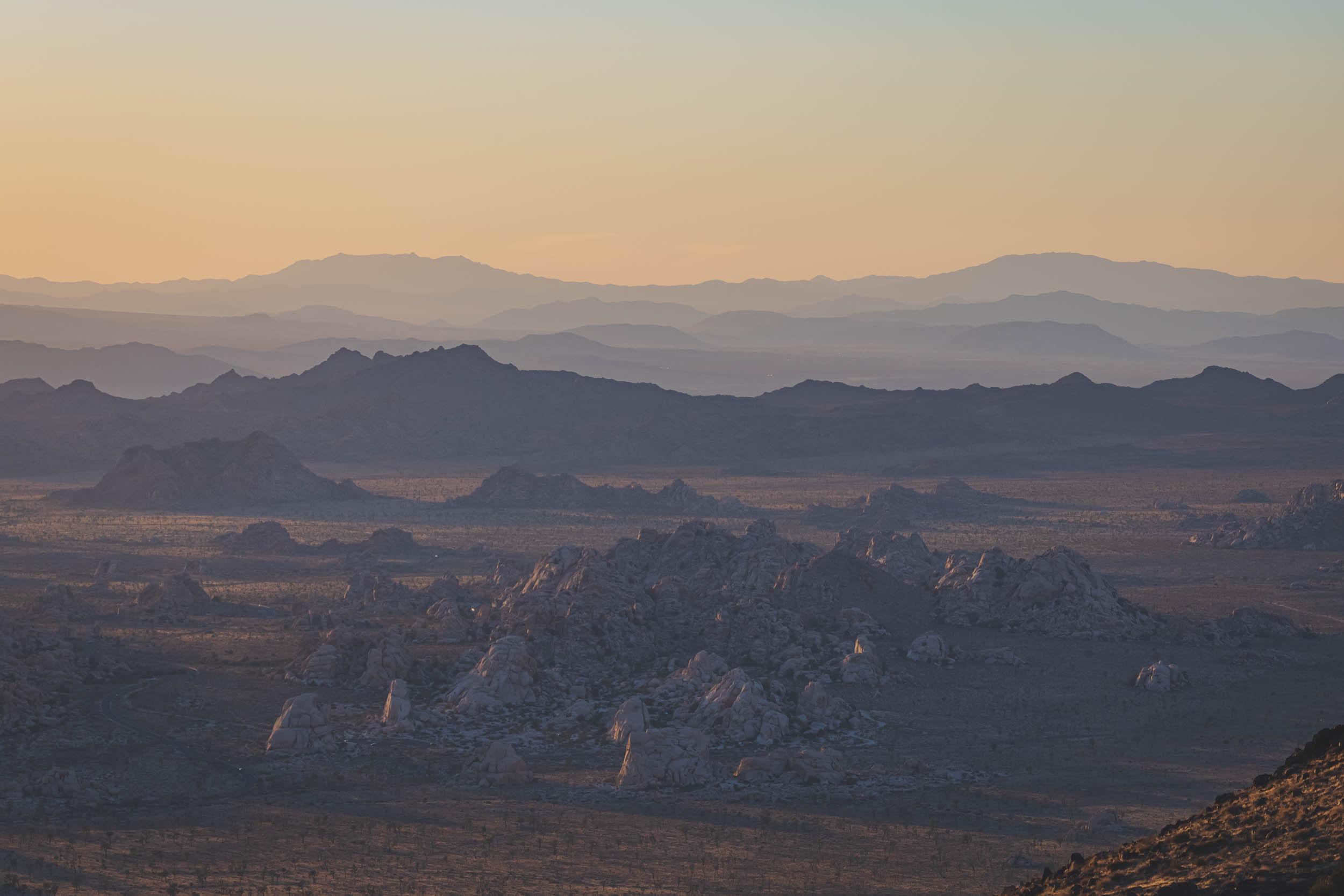 Late in the day as the mountains and rocks in Joshua Tree National park reflect colorful light