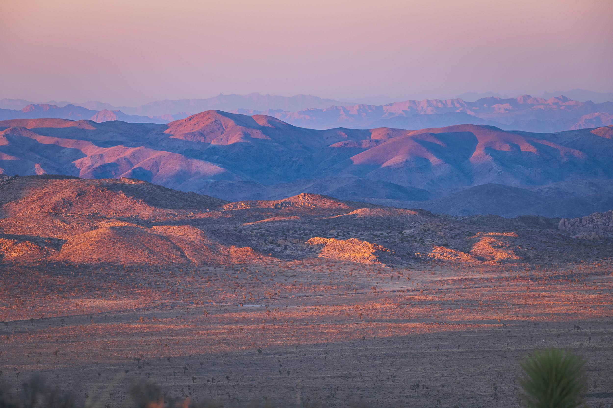 The setting sun casts a warm glow on the foothills of southern California