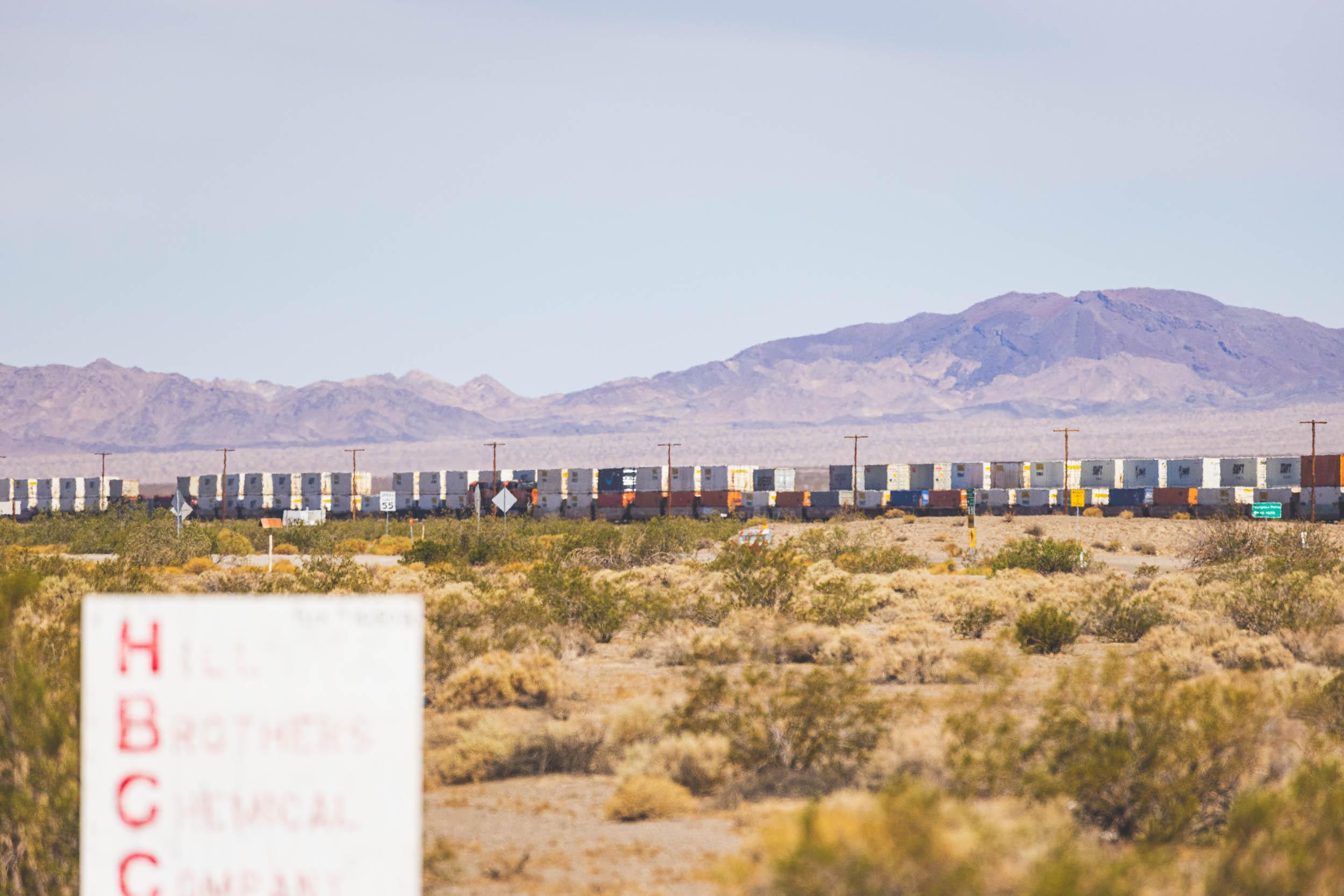 A long train passes in the desert