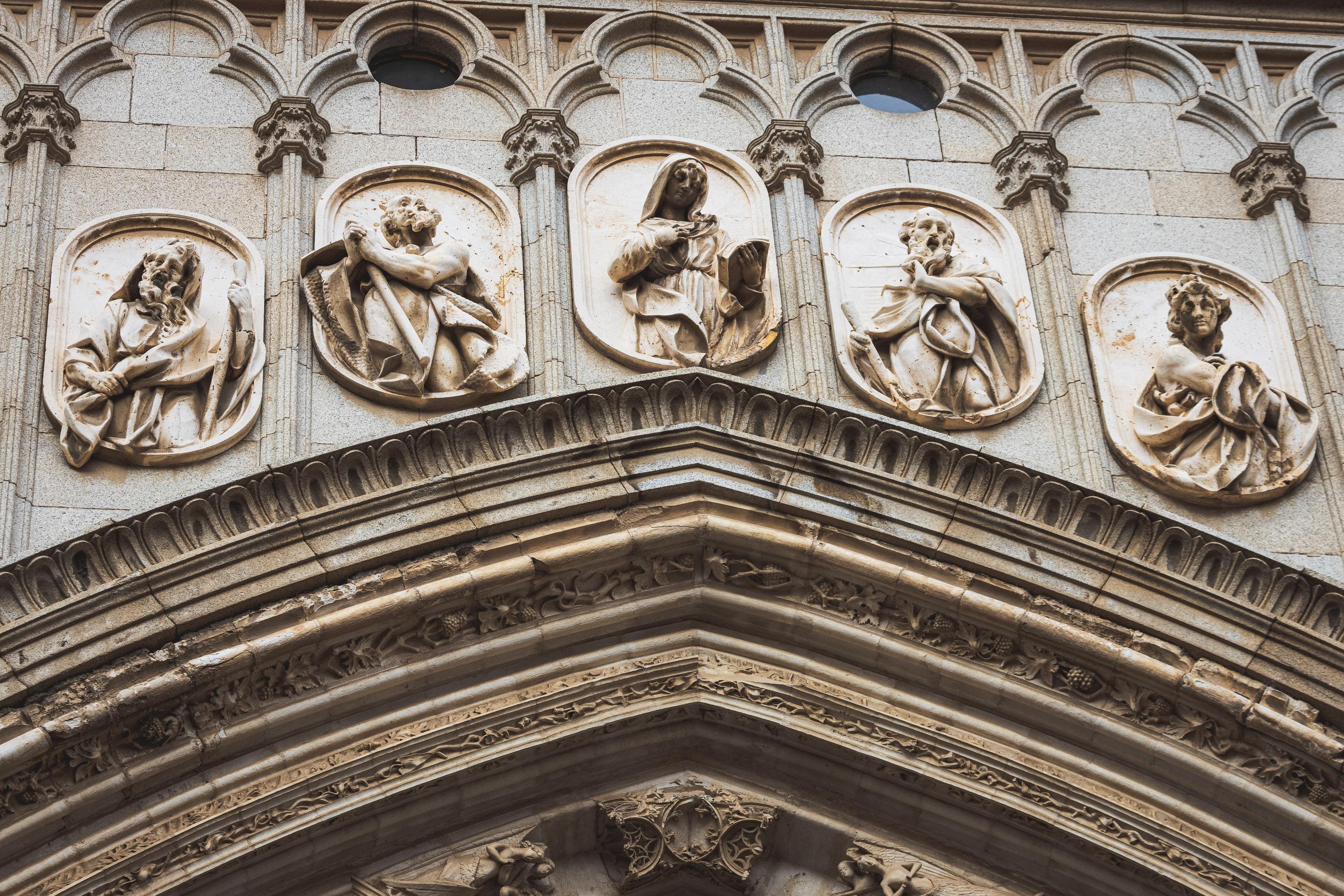 Architectural reliefs and statues outside Tolego Cathedral in Spain, carved into aging rock