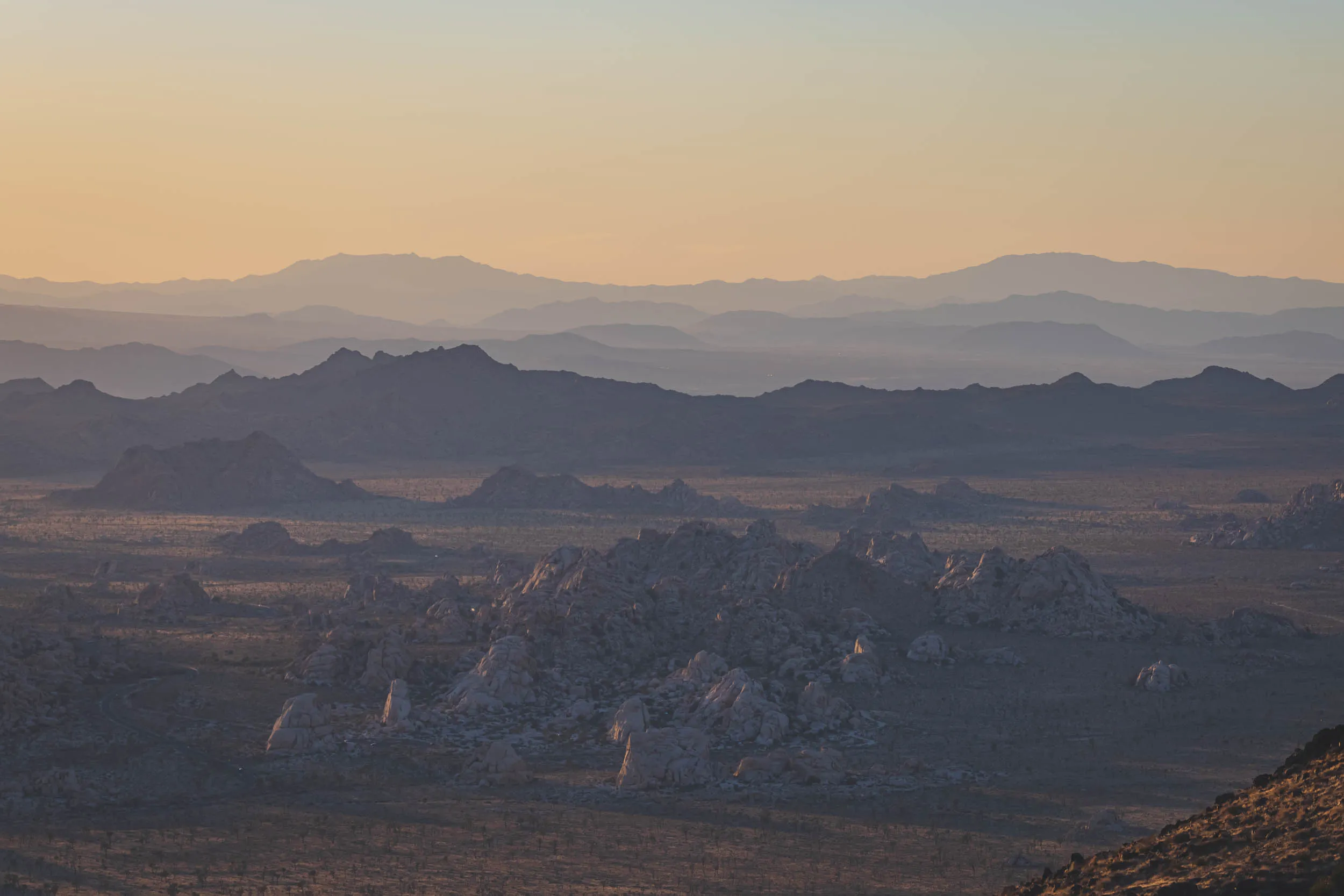 Late in the day as the mountains and rocks in Joshua Tree National park reflect colorful light