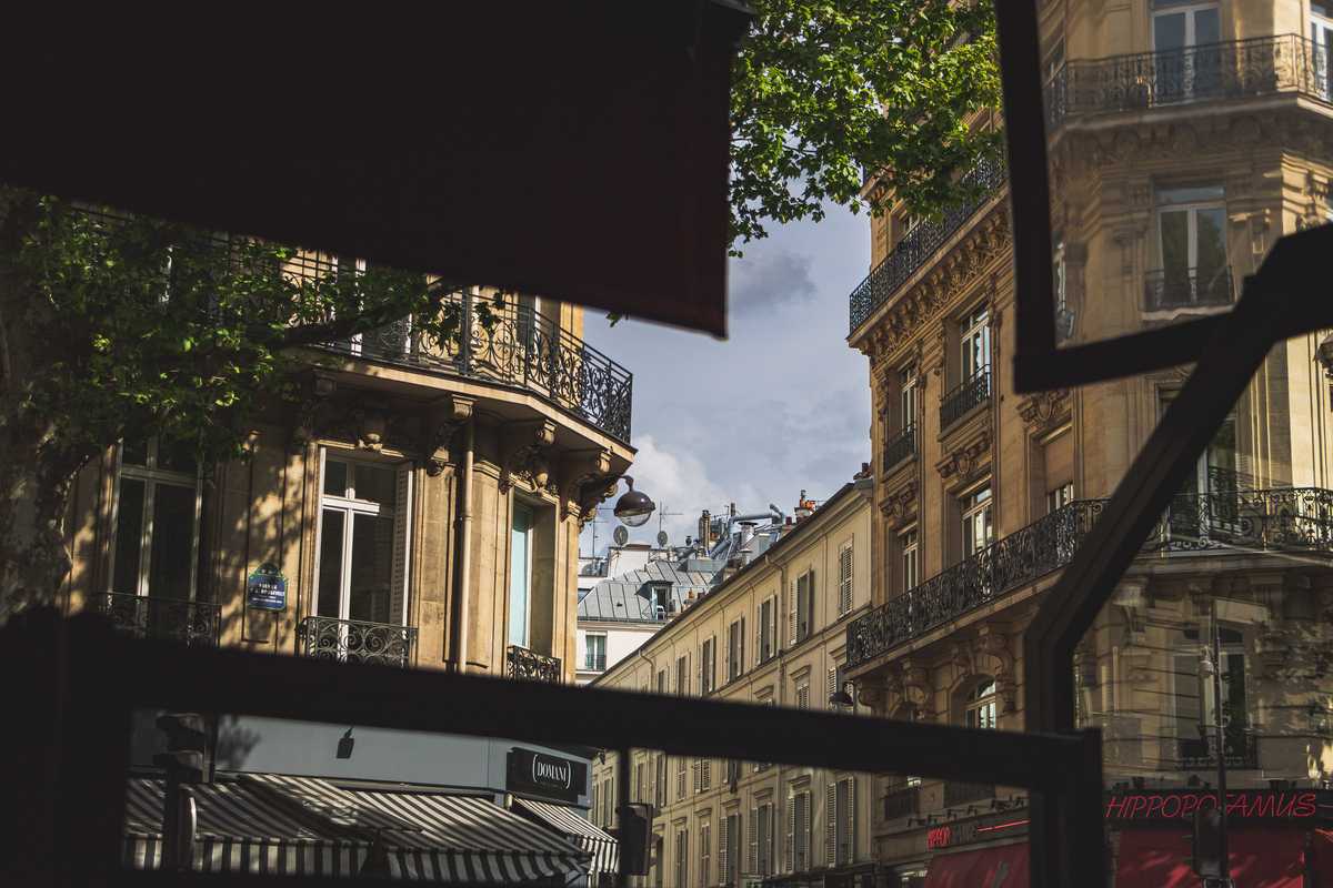 Looking up through a terrace at a cafe, peering at the surrounding buildings on a slightly rainy day
