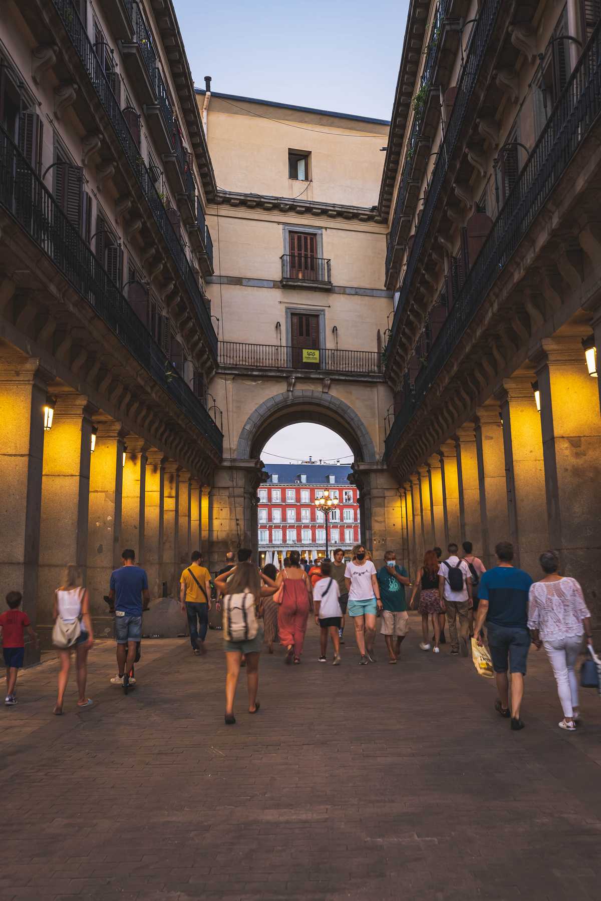 Walking through one of the open passages to Plaza Mayor in the early evening with people out enjoying their lives in the city