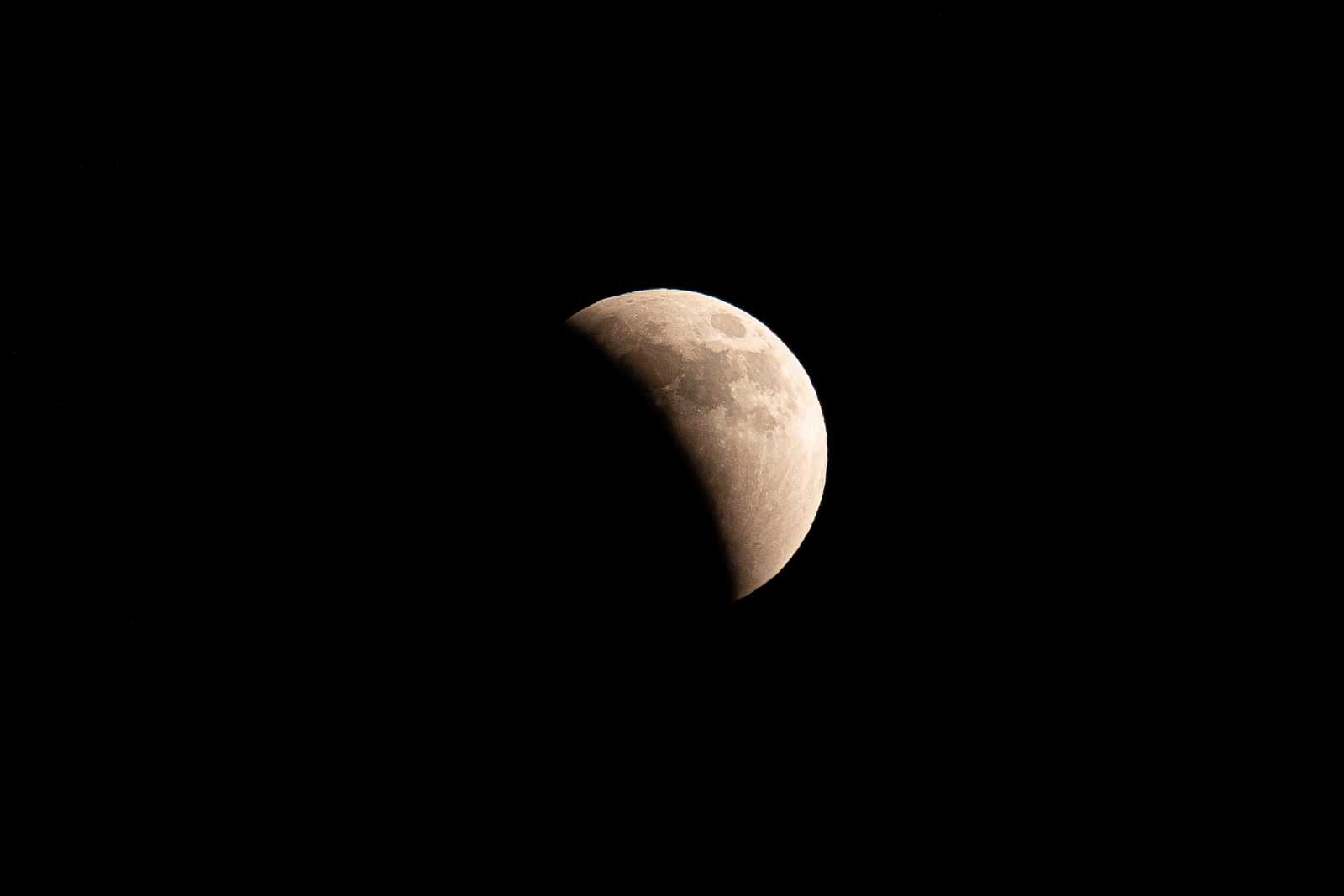 The full moon during a lunar eclipse, showing about half covered in shadow
