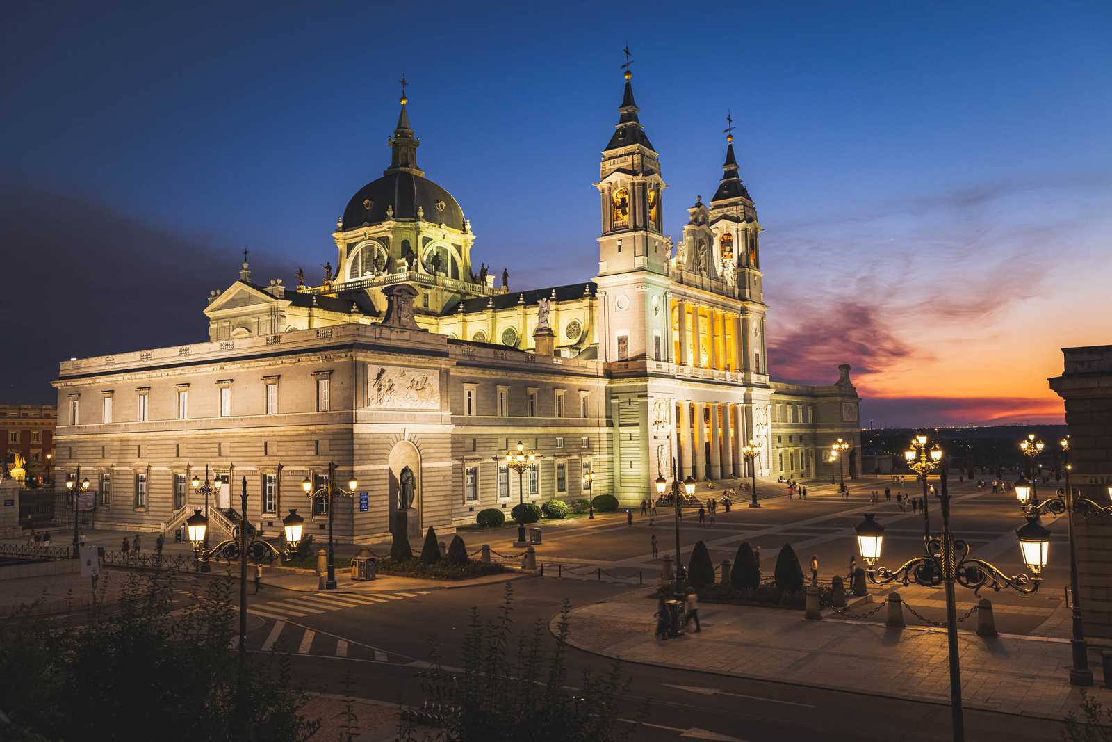 A photo of the Catedral de la Almudena and plaza in Madrid during the sunset