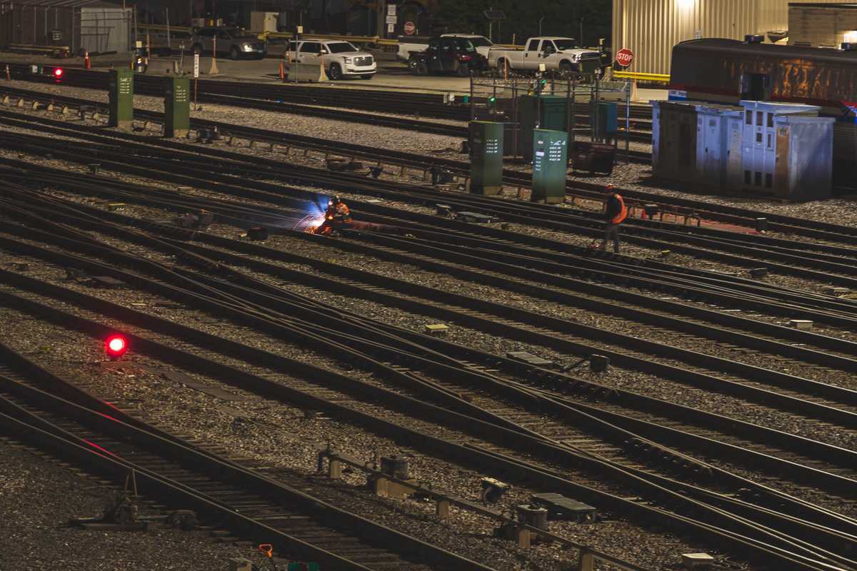 Two men work on railroad tracks
