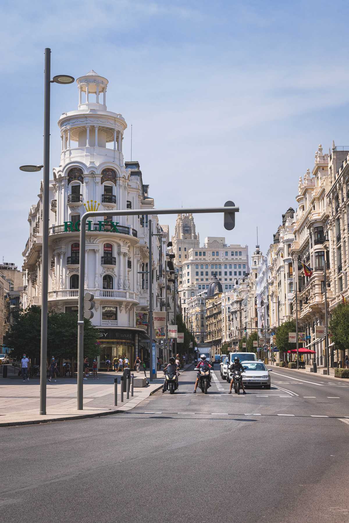 Hotels, shops, and apartments flank a busy street in Madrid