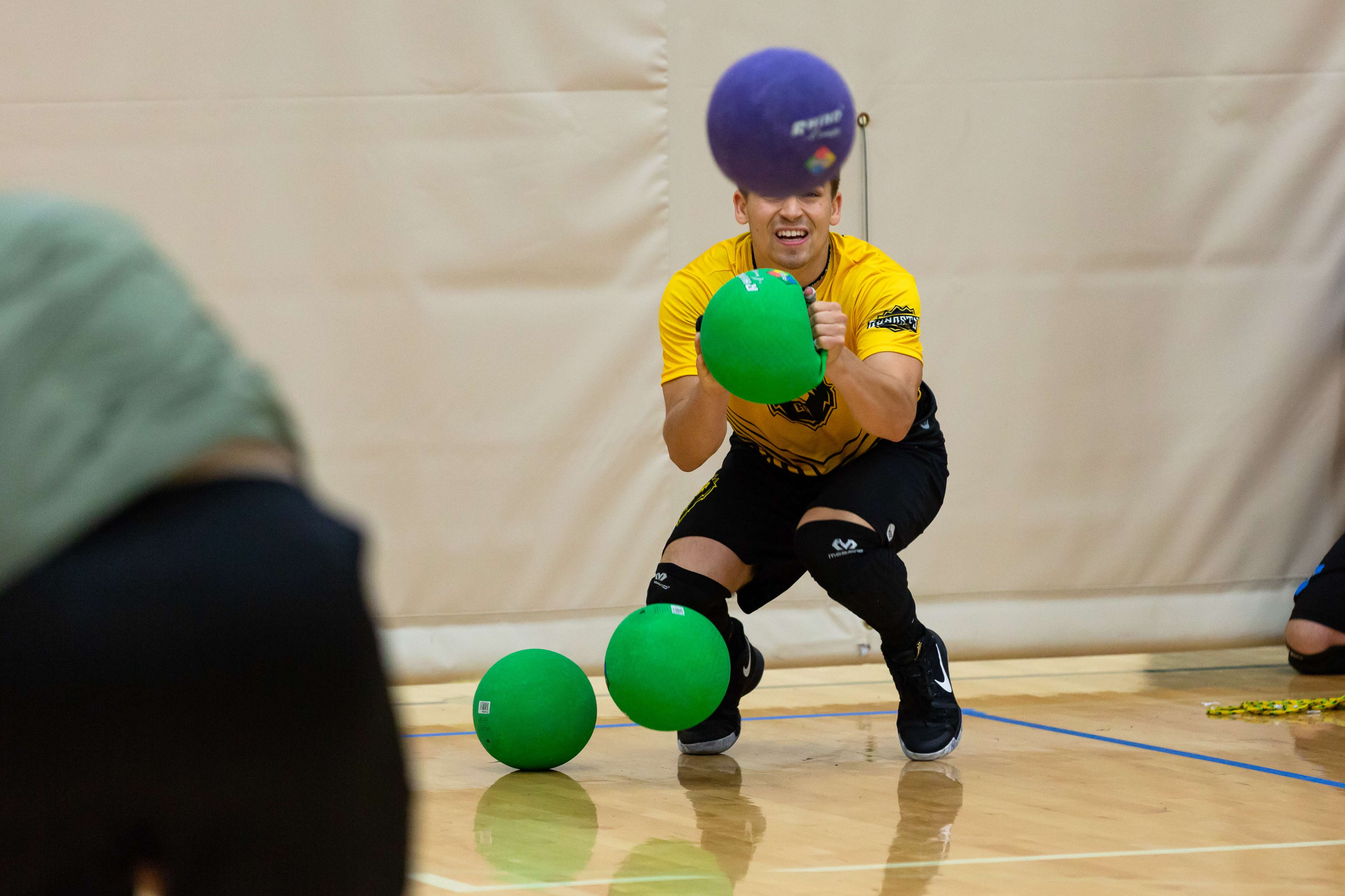 A dodgeball player ducks to prepare to dodge an incoming ball
