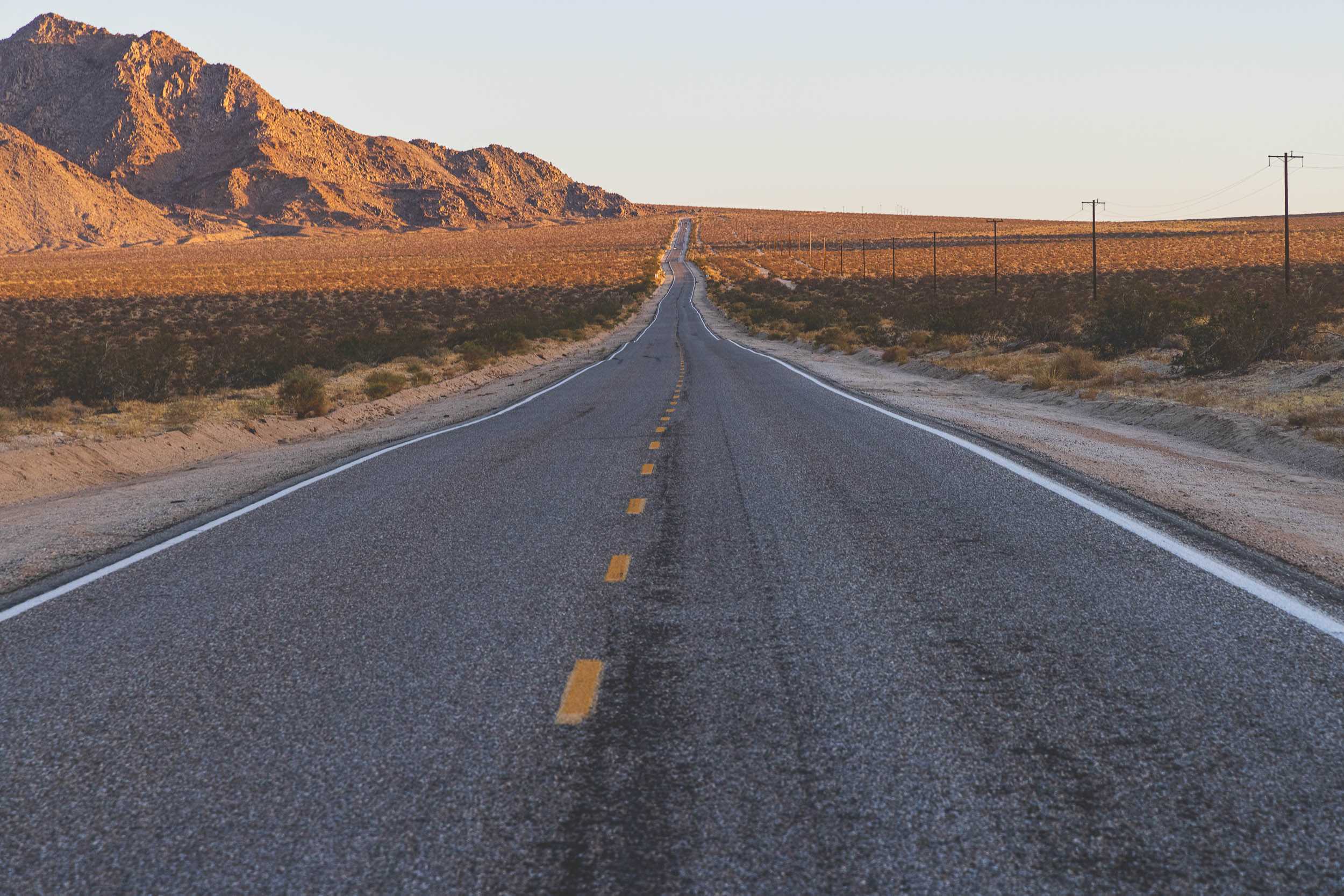 A photo of an undulating desert road running straight into the distance