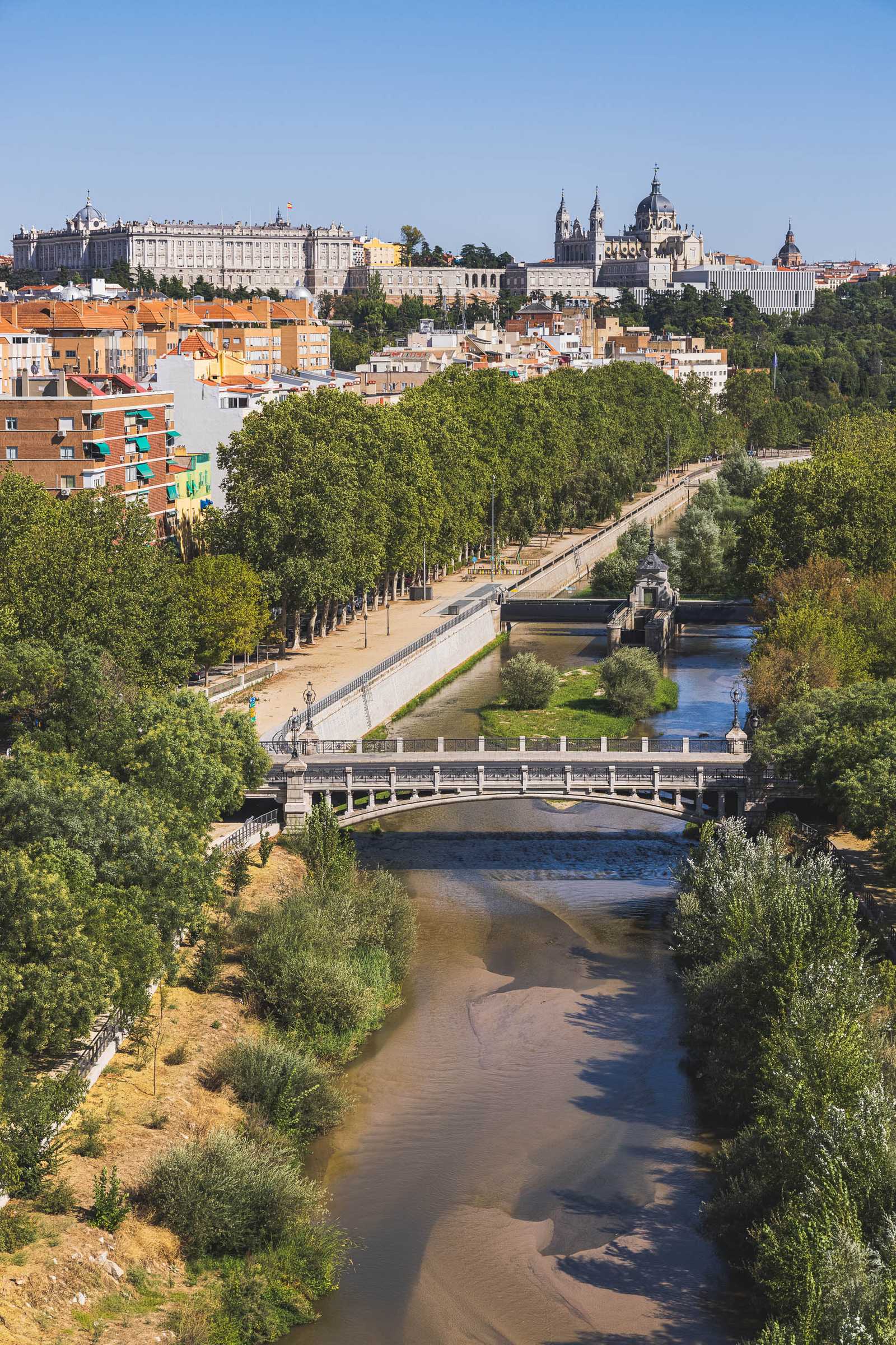 Rio Manzanares flowing in the valley below Madrid and the Royal Palace