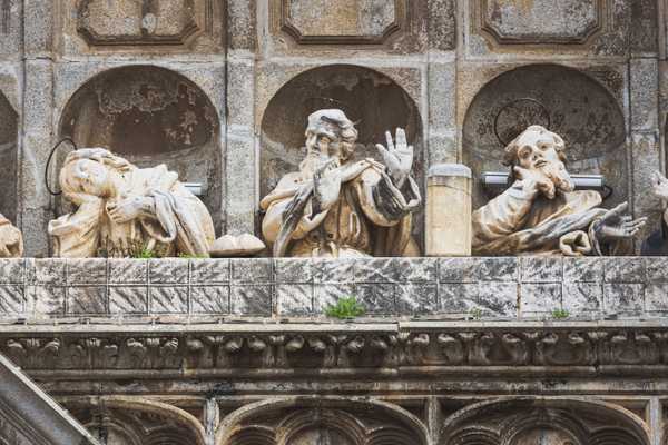 Statues of saints making gestures carved into one of the entryways to the Toledo Cathedral.