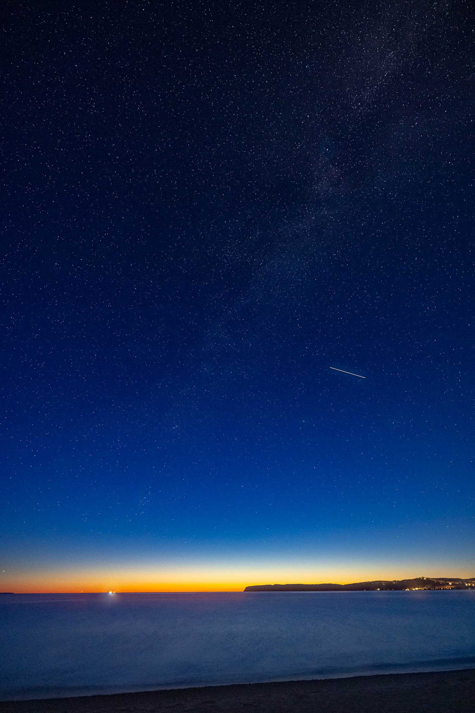 The path of the International Space Station crossing the Milky Way at the break of dawn