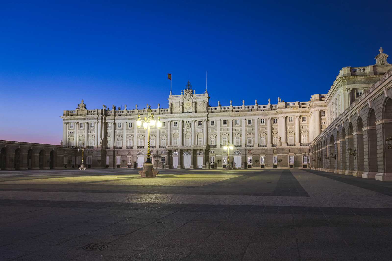 The Royal Palace across a large plaza in the last light of the day