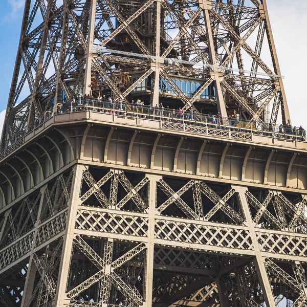 The second floor of the Eiffel Tower, where many tiny people are visible peering over the side